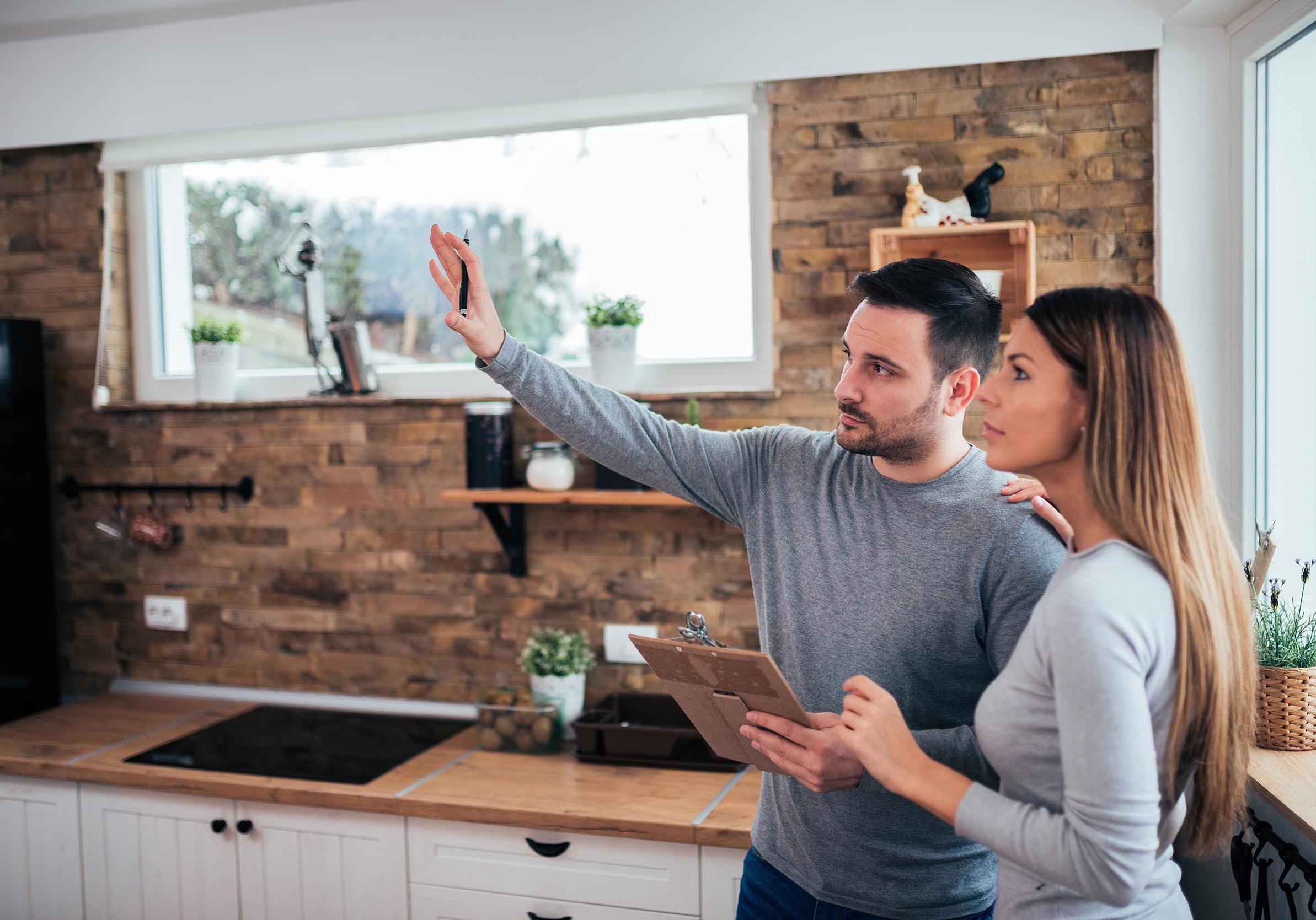 Couple talking about home renovation. Standing in the kitchen and discussing apartment renovation ideas.